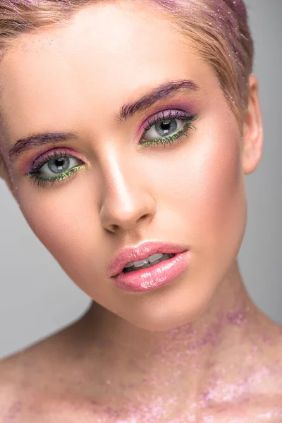 Attractive woman with violet makeup looking at camera isolated on grey — Stock Photo