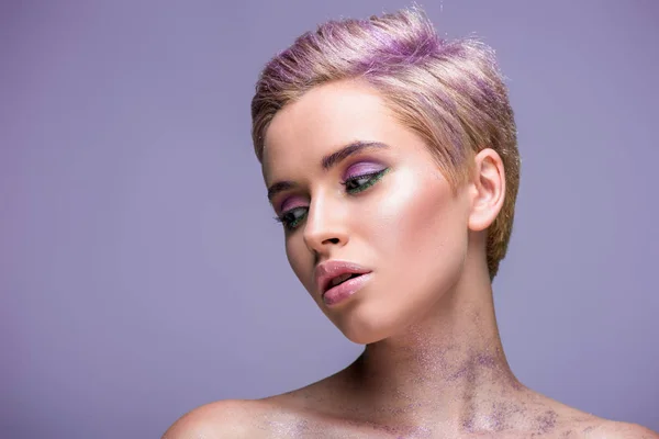 Attractive woman with violet glitter on neck and short violet hair isolated on violet — Stock Photo