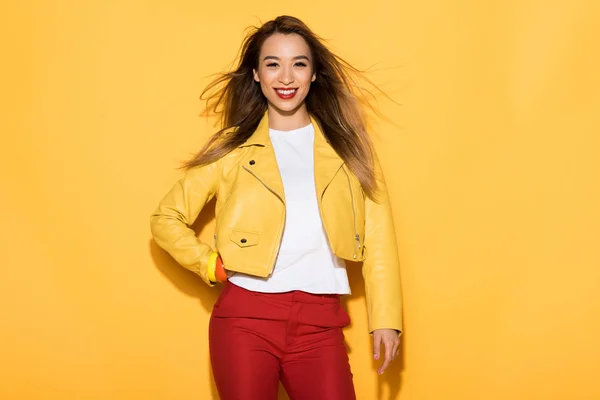 Joven asiático modelo femenino posando sobre amarillo fondo - foto de stock