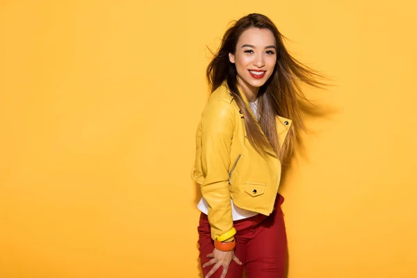Atractivo asiático modelo femenino posando aislado sobre amarillo fondo - foto de stock