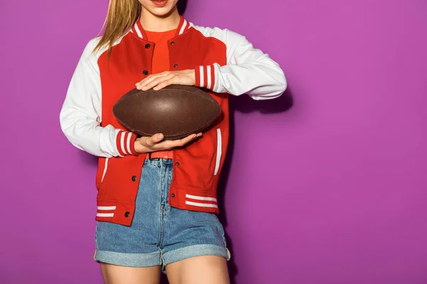 Schnappschuss von sportlicher junger Frau mit Rugbyball isoliert auf Veilchen — Stockfoto