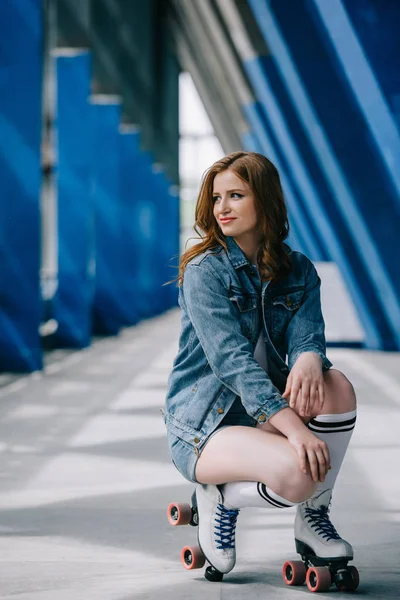 Jeune femme élégante en vêtements denim, chaussettes hautes et patins à roulettes rétro regardant loin — Photo de stock