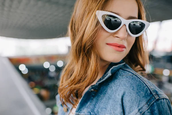 Retrato de mujer de moda sonriente en ropa de mezclilla y gafas de sol retro - foto de stock