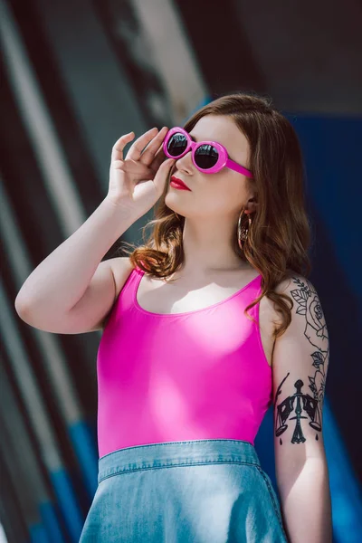 Portrait of young beautiful woman in pink retro sunglasses — Stock Photo