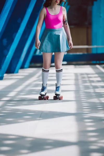 Tiro cortado de menina em saia de ganga patinação em patins de rolo vintage — Fotografia de Stock