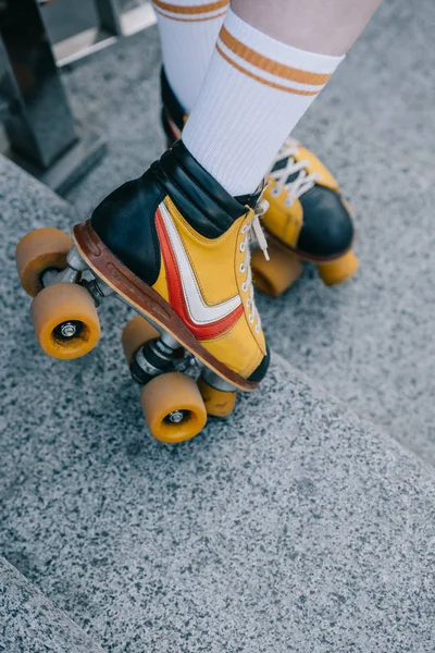 Gros plan partiel fille sur fille portant patins à roulettes sur les escaliers — Photo de stock