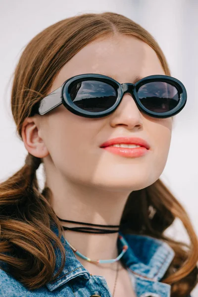 Nahaufnahme Porträt einer schönen jungen Frau mit Sonnenbrille, die im Freien wegschaut — Stockfoto