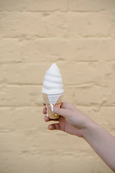 Vista parcial de cerca de la niña sosteniendo delicioso helado en cono de gofre - foto de stock