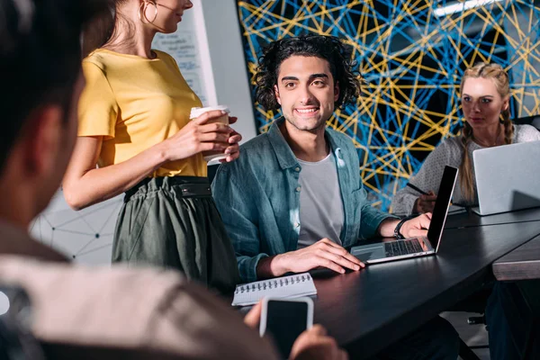 Cropped shot of business colleagues having meeting at table with laptops in modern office — Stock Photo