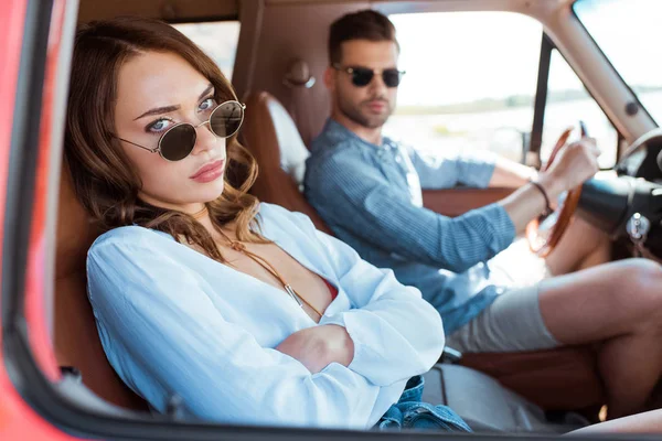 Foyer sélectif de belle femme bouleversée assis dans la voiture avec son petit ami — Photo de stock