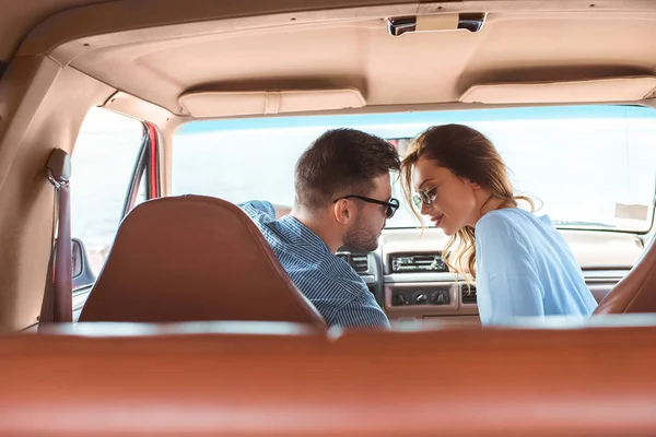 Beau jeune couple va embrasser en voiture — Photo de stock
