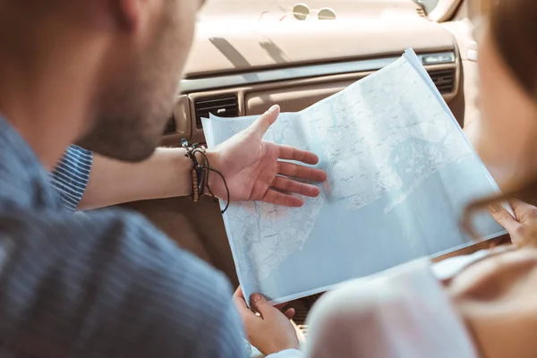 Ausgeschnittene Ansicht von Reisenden, die sich die Karte im Auto ansehen — Stockfoto