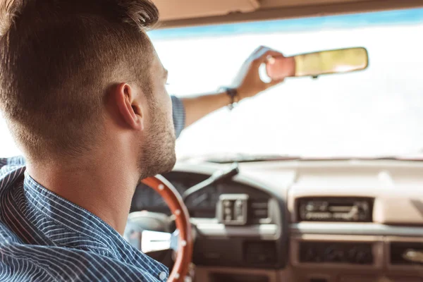 Back view of male driver looking at rearview mirror in car — Stock Photo