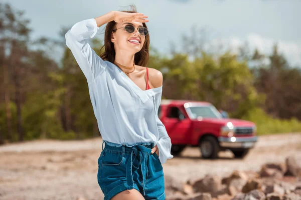 Allegra giovane donna in occhiali da sole in viaggio su strada — Foto stock