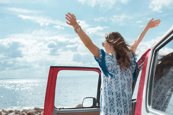 Glückliche junge Frau im Auto mit Blick aufs Meer — Stockfoto