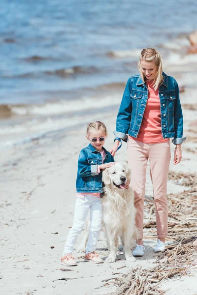 Belle mère et enfant avec chien en promenade près de la mer — Photo de stock