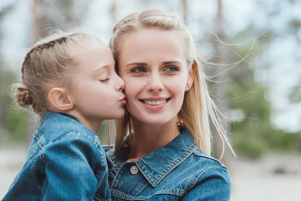 Kleine entzückende Tochter küsst ihre blonde Mutter — Stockfoto