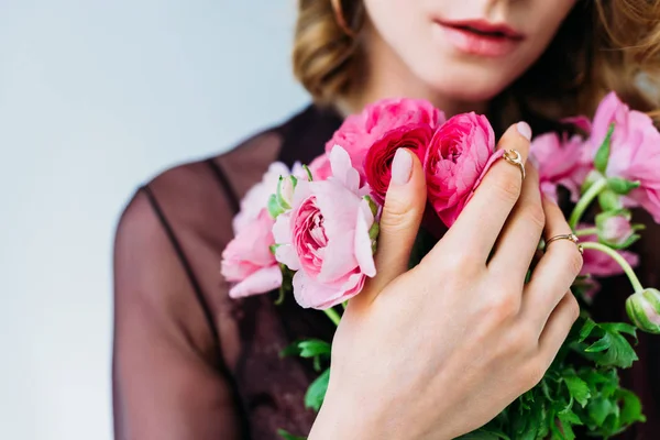 Vista ravvicinata della ragazza che tiene teneri fiori rosa isolati sul grigio — Foto stock