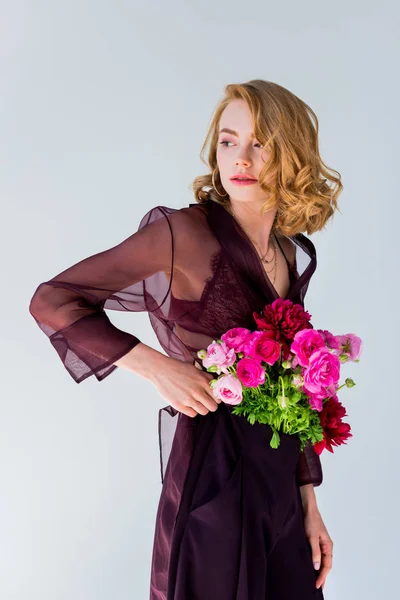 Elegante junge Frau mit schönen Blumen, die isoliert von grau wegschauen — Stockfoto
