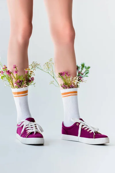 Teilansicht weiblicher Beine mit schönen Blumen in Socken isoliert auf grau — Stockfoto