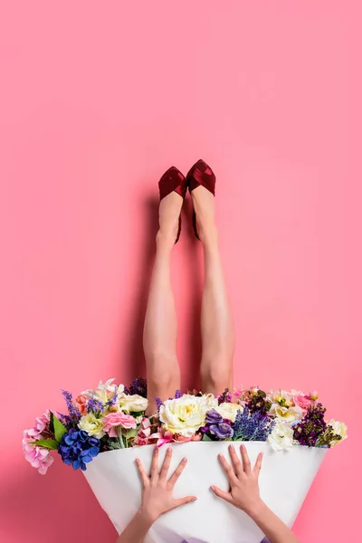 Upside down of girl in high heeled shoes and skirt with beautiful flowers isolated on pink — Stock Photo