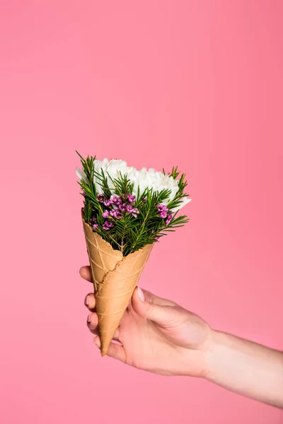 Cropped shot of girl holding waffle cone with beautiful flowers isolated on pink — Stock Photo