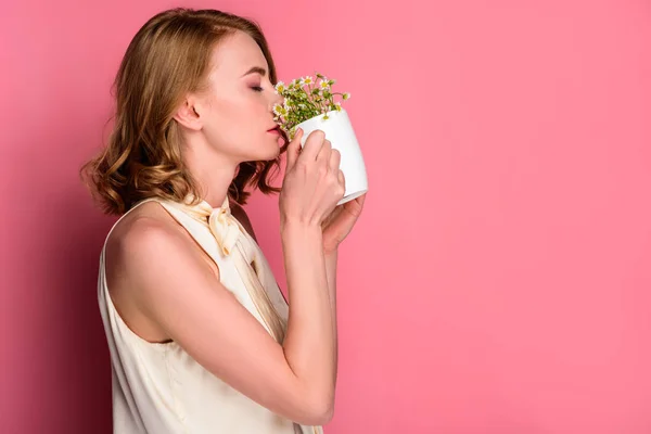 Vista lateral da jovem bebendo de xícara com camomilas isoladas em rosa — Fotografia de Stock