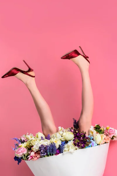 Plan recadré de fille en chaussures à talons hauts et jupe avec de belles fleurs sur rose, vue à l'envers — Photo de stock