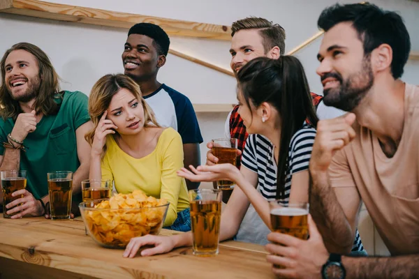 Group of multicultural friends with beer and chips watching soccer match at bar — Stock Photo