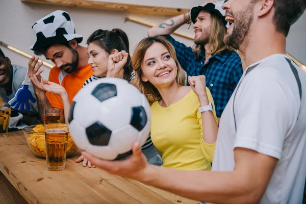 Эмоциональная мультикультурная группа друзей, смотрящих футбольный матч в баре — стоковое фото