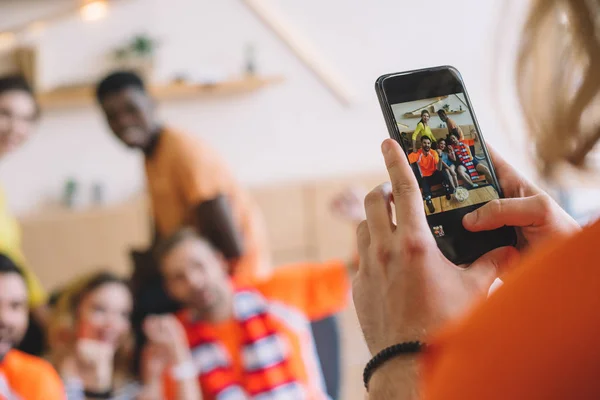 Tiro cortado de homem tirar fotos de amigos no smartphone em casa — Fotografia de Stock
