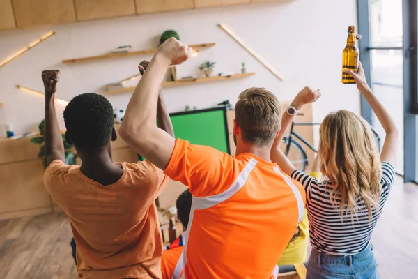 Vue grand angle du groupe d'amis célébrant et faisant des gestes oui tout en regardant le match de football à la maison — Photo de stock