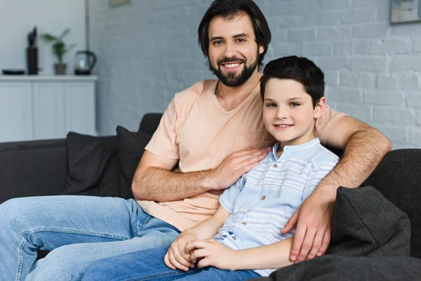 Retrato de la familia feliz descansando en el sofá en casa - foto de stock