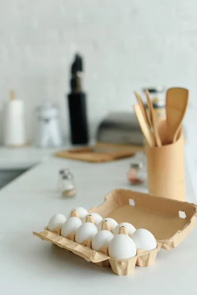 Close up view of raw chicken eggs in box on tabletop in kitchen — Stock Photo