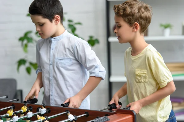 Petits garçons concentrés jouant au baby-foot ensemble à la maison — Photo de stock