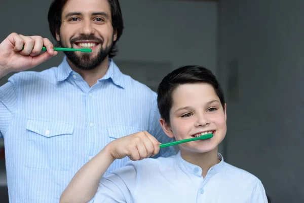 Portrait de père et fils brossant les dents ensemble à la maison — Photo de stock