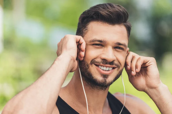 Porträt eines jungen Mannes, der mit Kopfhörern Musik hört — Stockfoto