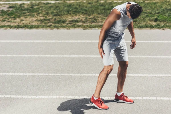 Молодий спортивний бігун отримує травму ноги під час бігу — стокове фото