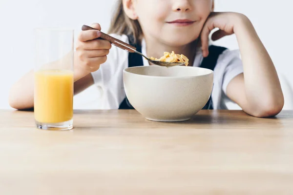 Cropped shot of little schoolgirl eating healthy breakfast isolated on white — Stock Photo