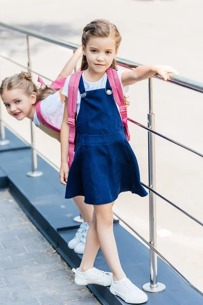 Studentesse con zaini rosa che giocano per strada — Foto stock