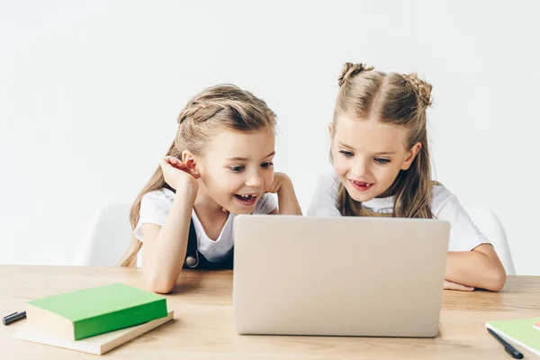 Aufgeregte kleine Schulmädchen mit Laptop zum Lernen isoliert auf weiß — Stockfoto