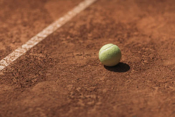 Palla da tennis sdraiato sul campo sotto la luce del sole — Foto stock