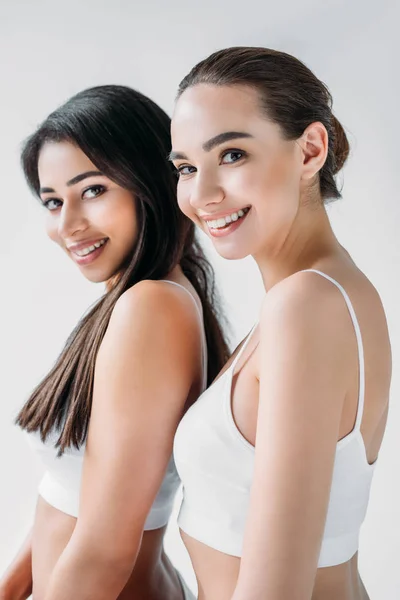 Lächeln attraktive multikulturelle Frauen posieren isoliert auf grauem Hintergrund — Stockfoto