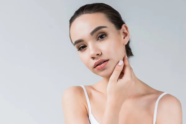 Portrait of attractive caucasian woman with hand on face isolated on gray background — Stock Photo