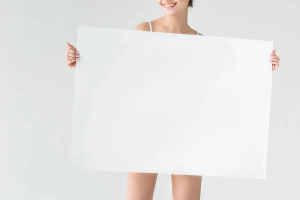 Cropped image of smiling woman holding blank banner isolated on gray background — Stock Photo