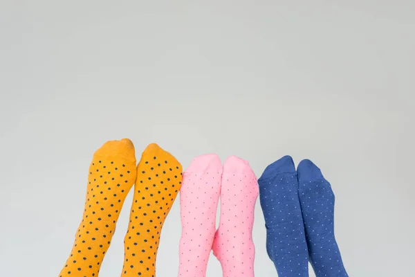 Vue partielle des jambes féminines dans différentes chaussettes colorées isolées sur fond gris — Photo de stock