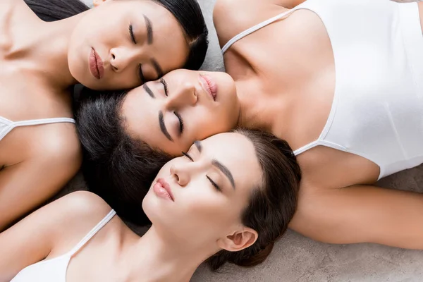 Top view of beautiful tender multicultural girls with closed eyes — Stock Photo