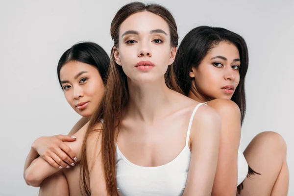 Encantadoras meninas multiculturais posando juntos, isolados em cinza — Fotografia de Stock