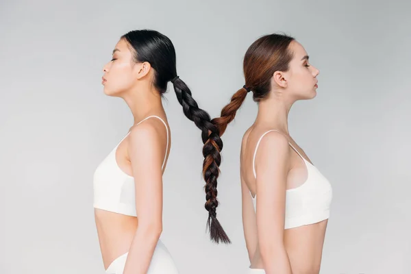 Beautiful brunette multiethnic girls with hair in one braid, isolated on grey — Stock Photo