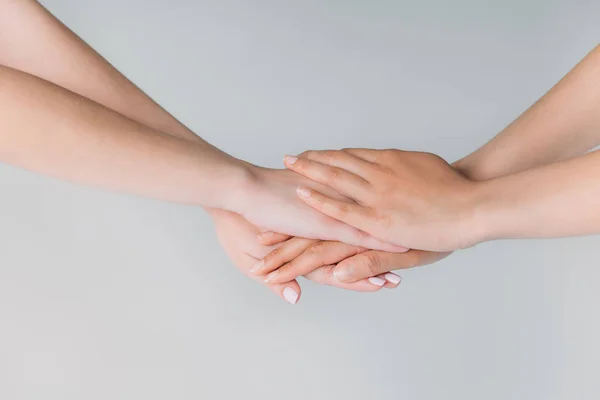 Visão parcial de mulheres de mãos dadas, isoladas em cinza, conceito de união — Fotografia de Stock